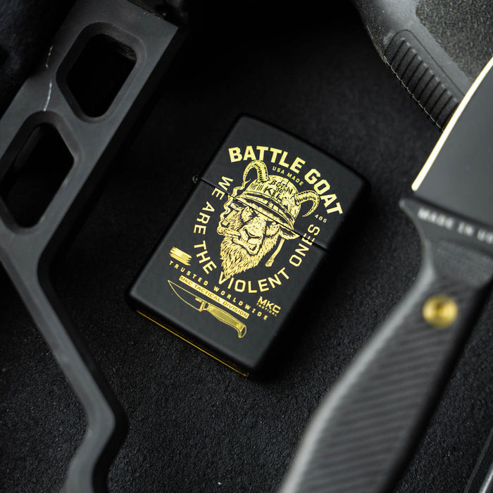 BATTLE GOAT ZIPPO lighter featuring a lion graphic and bold text, placed alongside a knife and tactical gear.