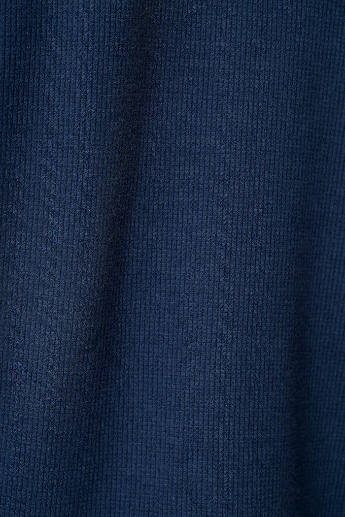 A close-up of a dark navy blue knit fabric with a waffle texture.