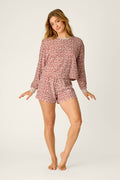 A person poses barefoot against a plain light background, wearing the P.J. Salvage Boyfriend Boxer Leopard Print Long Sleeve & Shorts PJ Set.