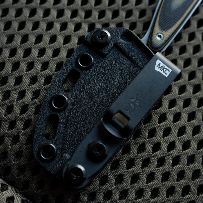 Kydex sheath for Castle Rock knife, featuring secure attachment points and durable black finish for outdoor use.