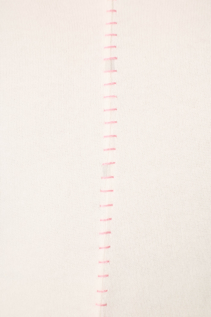Close-up of the Cheeky Paradise Sweatshirt by P.J. Salvage, highlighting its white fabric with a row of evenly spaced, vertical pink stitches down the center seam.