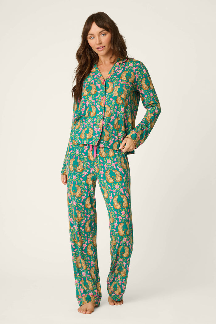 A woman wearing the P.J. Salvage Cheetah Bonita Dreams Cheetah Print Long Sleeve PJ Set stands barefoot against a plain light background.