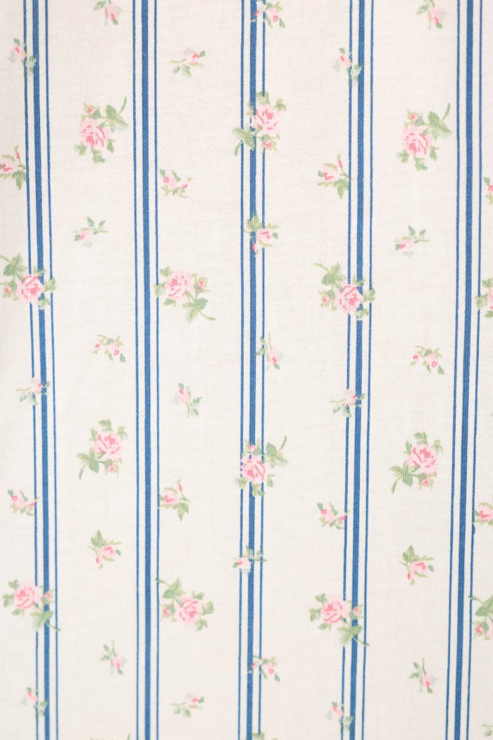 The P.J. Salvage Cotton Jersey Stripes & Blooms Cropped PJ Set features white fabric with vertical blue stripes and a repeating floral pattern of small pink roses and green leaves for a vintage, delicate look.