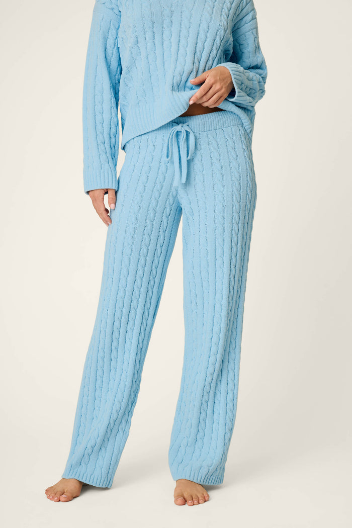 A person wearing the P.J. Salvage Cozy Chenille Cable Knit Cloud Blue Lounge Pants, styled with long sleeves and a drawstring waist, stands barefoot against a plain background.