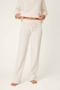 A person is wearing P.J. Salvage Cozy Chenille Cable Knit Ivory Lounge Pants, standing barefoot against a plain light background. The pants appear soft and cozy, and the matching top completes the comfortable look. The face is not visible.