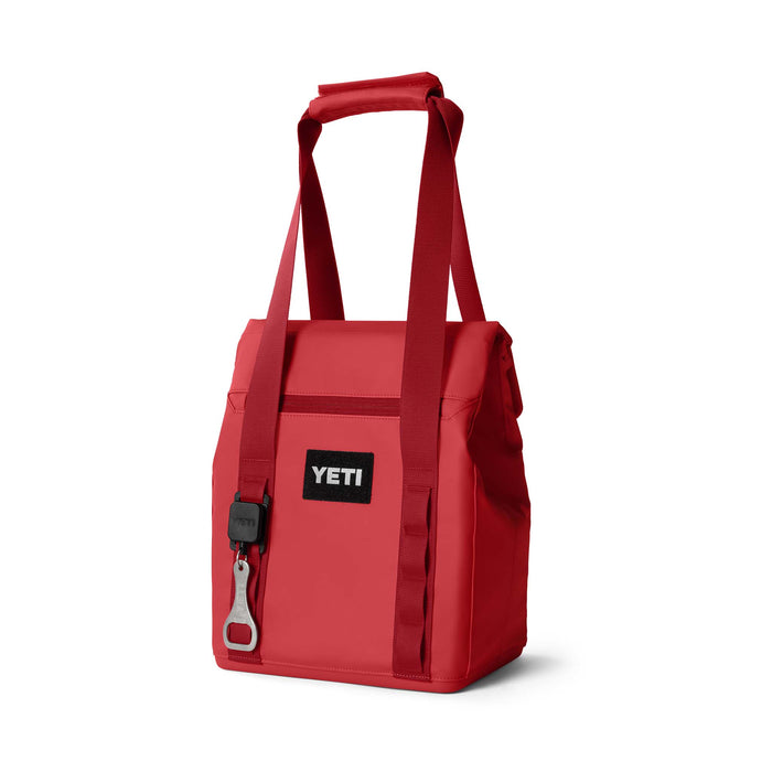 Angled front view of the tote in Rescue Red featuring the YETI logo, attached bottle opener, and shoulder straps.