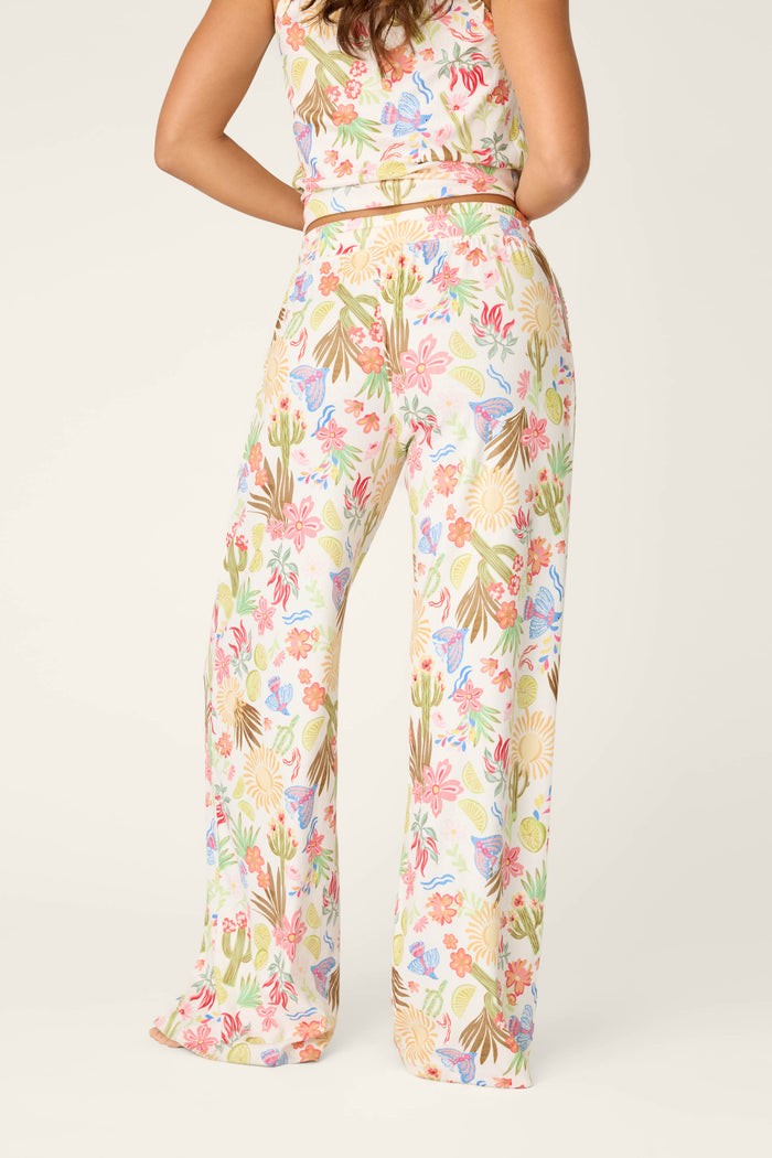 A person stands with their back to the camera, showcasing the Feelin' Prickly Desert Dreams Pajama Pants by P.J. Salvage—high-waisted, wide-leg, and perfectly comfy for cozy nights. The background is light and plain.