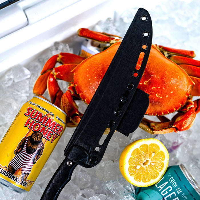 Flathead fillet knife with Kydex sheath on ice, surrounded by a crab, lemon, and craft beer cans.