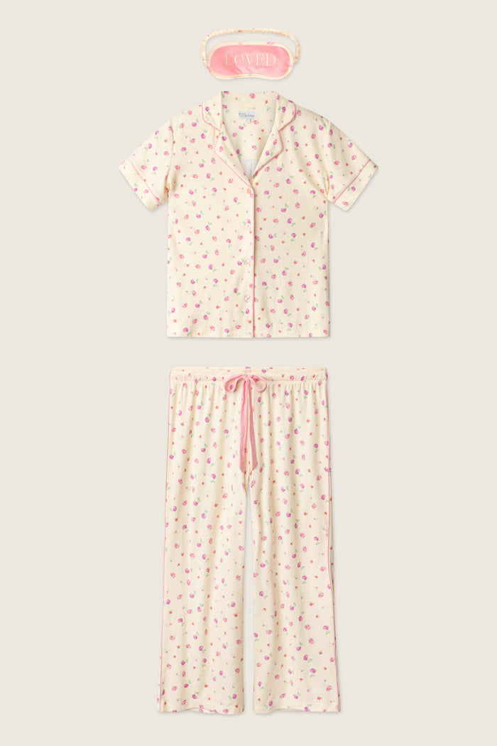 The P.J. Salvage For the Mamas Butter Blooms Cropped 3-Piece PJ Set includes a short-sleeved floral top, matching pants, and a pink “LOVED” sleep mask—offering cozy pointelle comfort for relaxing at home.