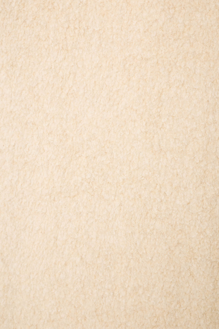 A close-up of soft, beige textured fabric with a plush, fleece-like look—perfect for the For the Mamas Sweetheart Banded Pants by P.J. Salvage.