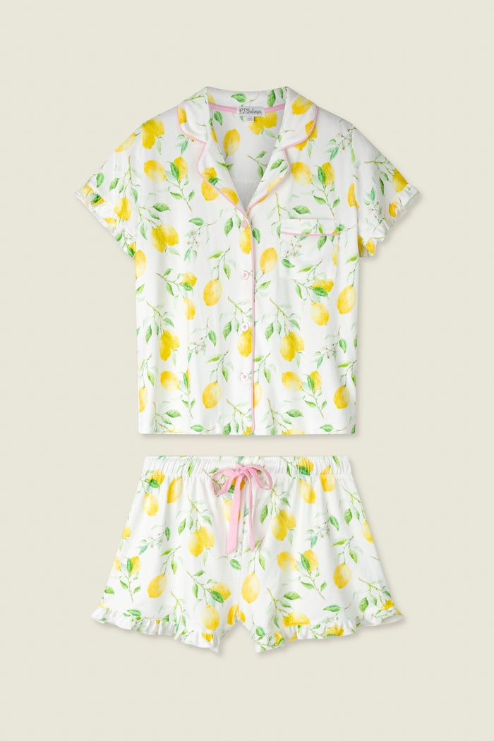 White fabric with yellow lemon and green leaf print, accented by pink trim and a pink drawstring.