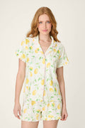 White fabric with a playful lemon and green leaf print, soft texture, and subtle ruffled detailing.