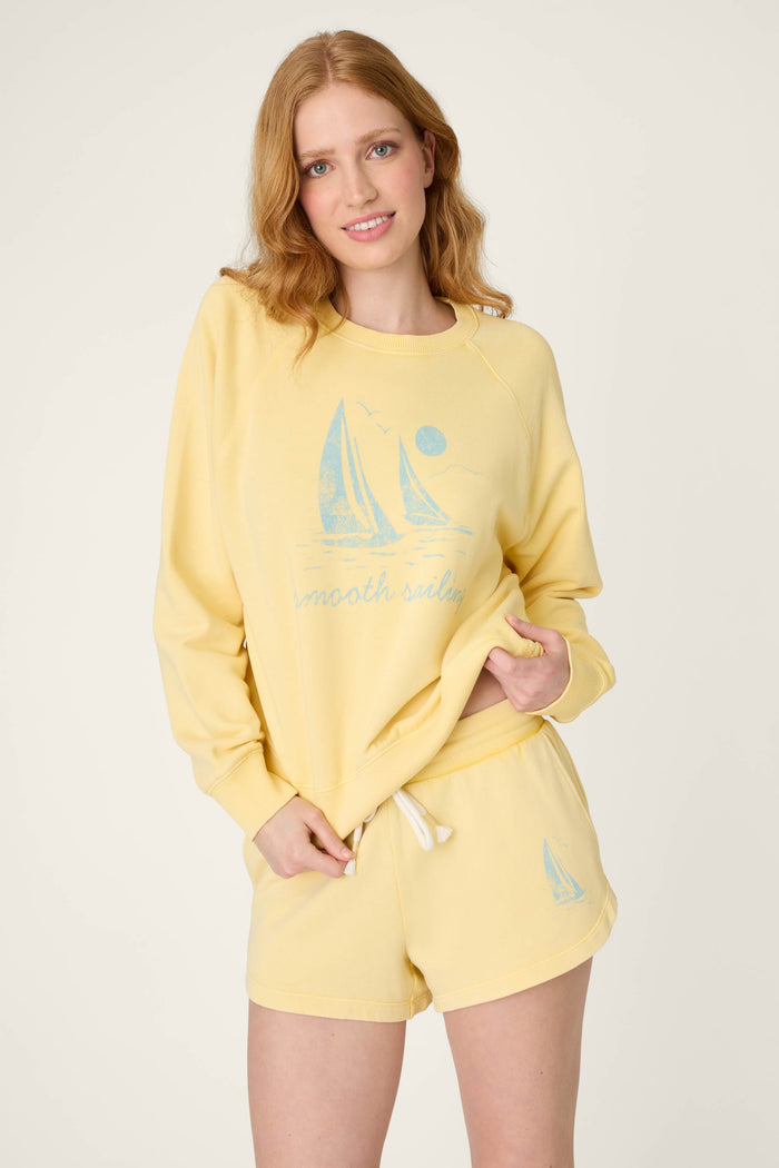 Light yellow fabric with a blue sailboat graphic and the words “smooth sailing” printed on it.