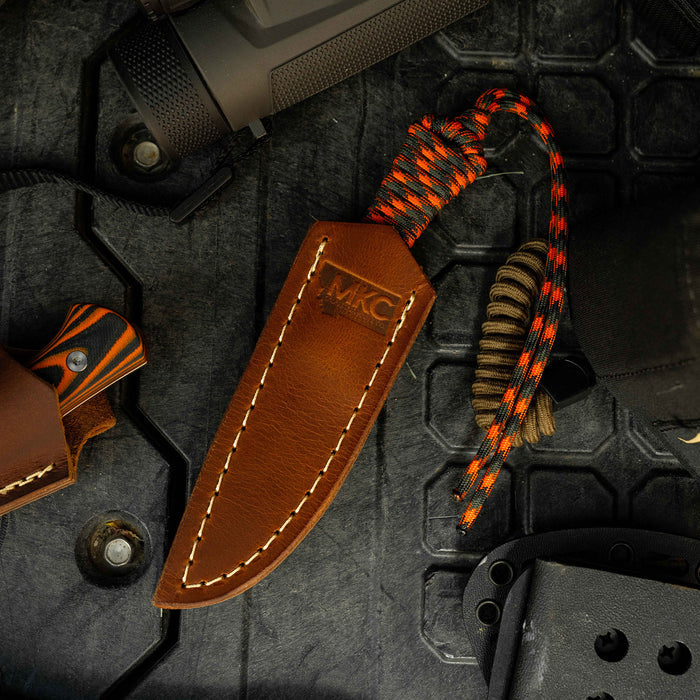 Brown leather sheath for the Mini-Speedgoat knife, featuring a concealed pocket carry design and paracord handle.
