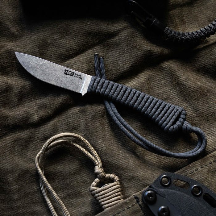 Mini Stoned Goat knife in grey with a textured blade and paracord handle, ideal for outdoor and everyday use.