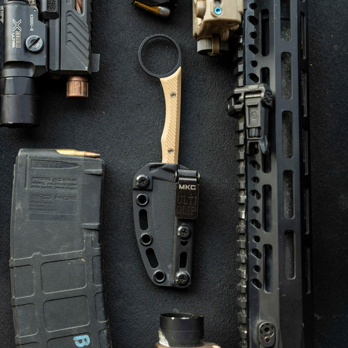 MINI WARGOAT knife in black and coyote with sheath, surrounded by tactical gear and accessories.