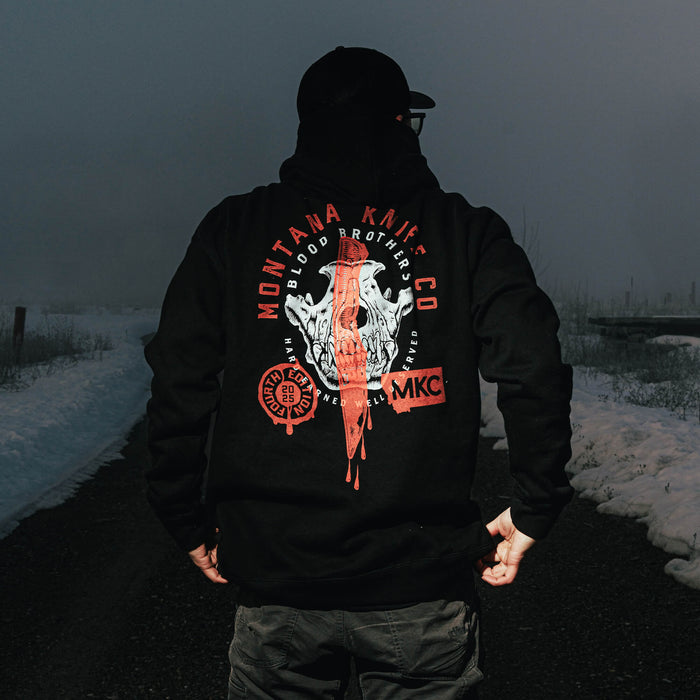 Black hoodie featuring the Montana Knife Company Blood Brothers design, showcasing a skull graphic and logo on the back.