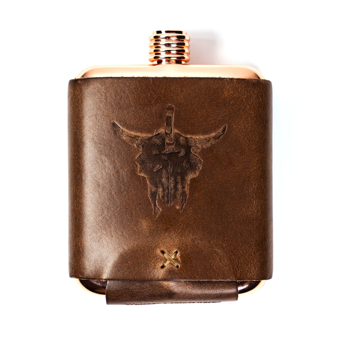 Limited run MKC copper flask with a leather sleeve featuring a bull skull design, ideal for outdoor enthusiasts.