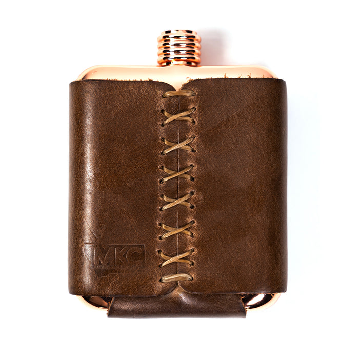 Limited run MKC copper flask with a stitched leather sleeve, designed for outdoor enthusiasts and professionals.