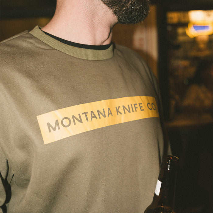 Olive crewneck sweatshirt featuring the Montana Knife Company logo, ideal for outdoor enthusiasts and working professionals.