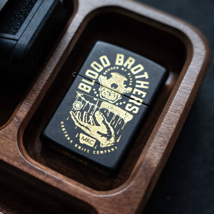 Montana Knife Company EDC dump tray featuring a black design with "Blood Brothers" graphic on a wooden base.