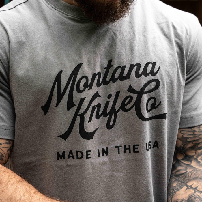 Gray Montana Knife Company Heritage Tee featuring bold black lettering, highlighting its USA-made quality.