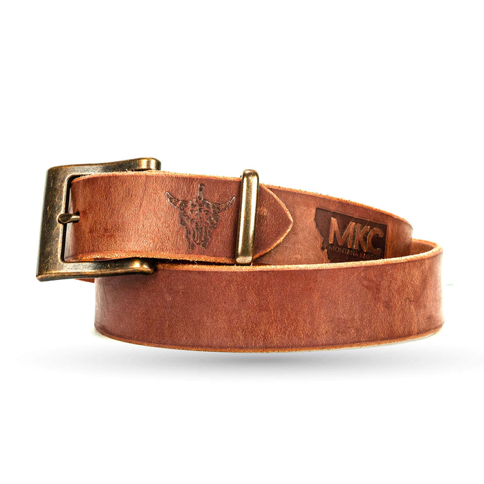 Brown leather belt from Montana Knife Company featuring a brass buckle and embossed logo, ideal for everyday wear.