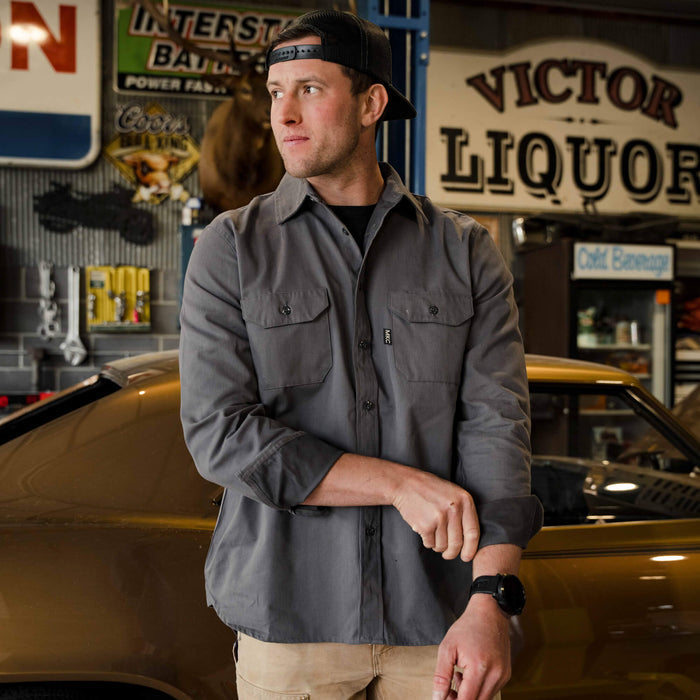 Graphite MKC shop shirt on a man in a garage, showcasing a rugged design ideal for outdoor work and everyday wear.
