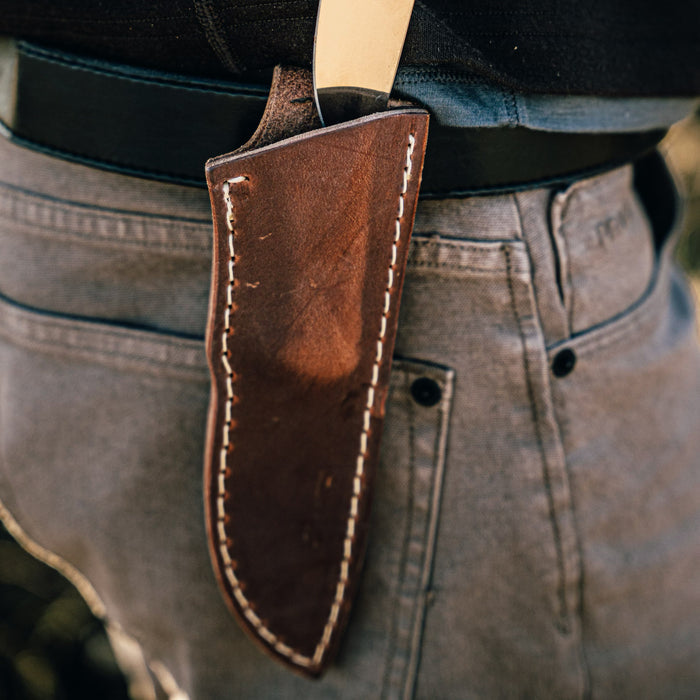 Vertical leather sheath designed for the MKC Whitetail knife, showcasing durable craftsmanship and a secure fit on a belt.