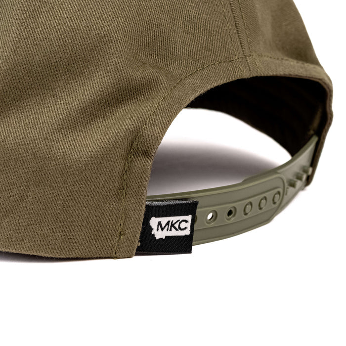 Olive green MKC Whitetail hat featuring an adjustable strap and logo tag, ideal for outdoor enthusiasts.