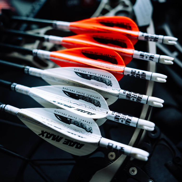 A close-up of MAX Stealth Arrow Vanes in orange and white, showcasing their sleek design and branding for archery use.