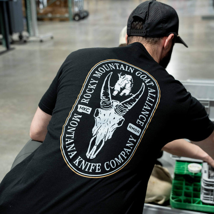 Black t-shirt featuring the Rocky Mountain Goat Alliance logo and Montana Knife Company branding on the back.