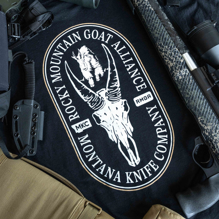 Black tee featuring the Rocky Mountain Goat Alliance logo with a skull design, surrounded by outdoor gear and tools.