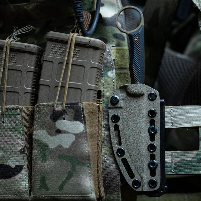 MOLLE-LOK attachment securing a knife sheath to tactical gear with magazine pouches in a camo pattern background.