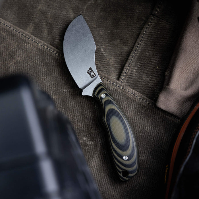 Montana Knife Company's PACKOUT SKINNER in green and black, featuring a curved blade and ergonomic handle, ideal for outdoor use.