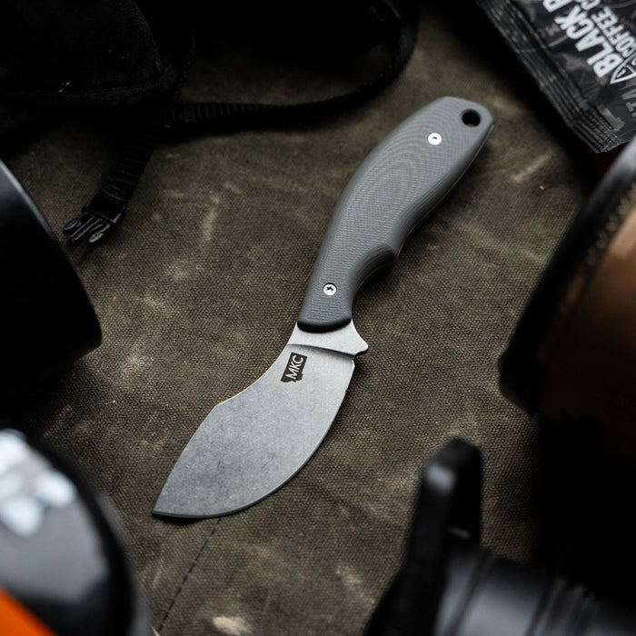 Montana Knife Company's PACKOUT SKINNER in grey, featuring a curved blade and ergonomic handle, ideal for outdoor use.