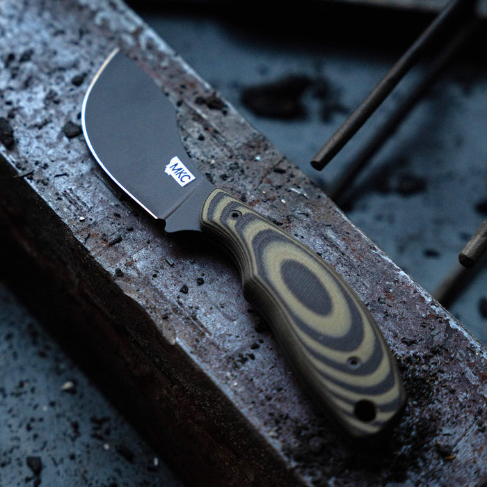 Montana Knife Company's PACKOUT SKINNER features a PVD-coated blade with a green and black patterned handle, ideal for outdoor use.