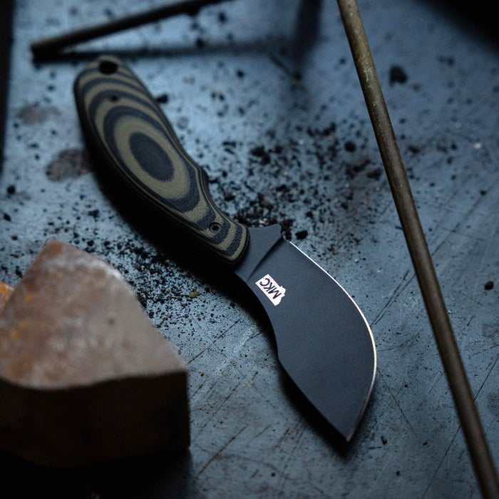 Montana Knife Company's PACKOUT SKINNER features a PVD-coated blade with a green and black handle, ideal for outdoor use.