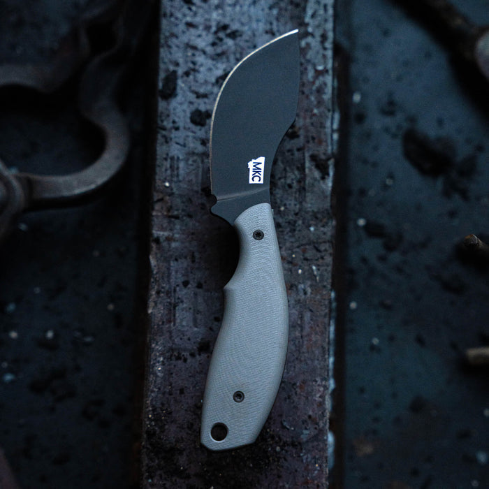 Montana Knife Company's PACKOUT SKINNER in PVD grey features a durable blade and ergonomic handle, ideal for outdoor use.