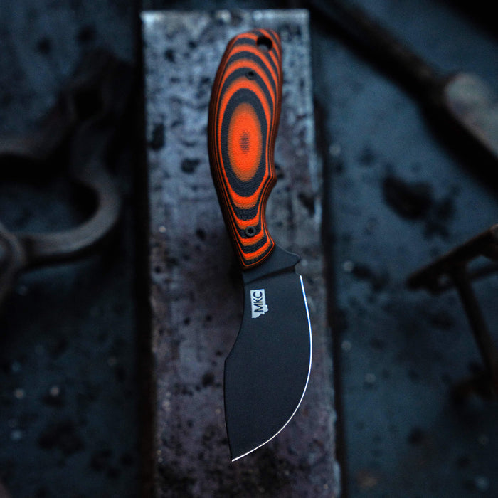 Montana Knife Company's PACKOUT SKINNER features an orange and black handle with a sleek black blade, ideal for outdoor use.