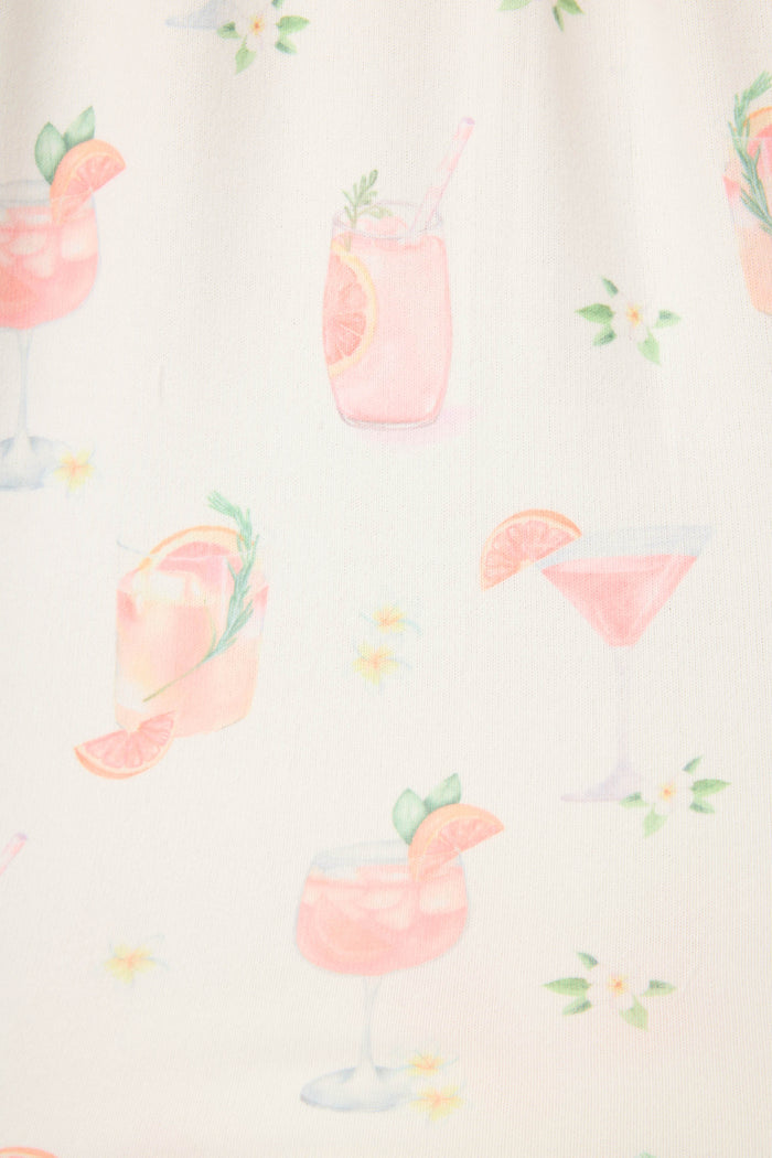 The Paloma Mama Sweet Sips Tank Top by P.J. Salvage features a breathable butter jersey ivory fabric with pink cocktail illustrations, citrus garnishes, herbs, and small white and yellow flowers—a fun sleepwear choice.