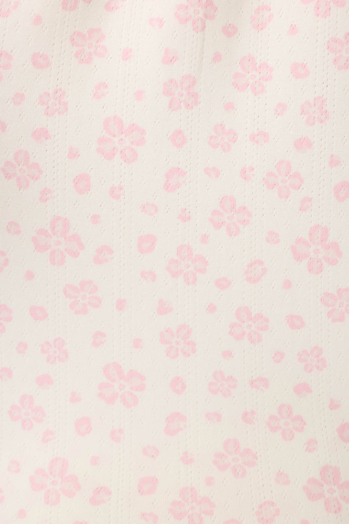 Close-up of the Pretty Petals Sweet Pink Floral Print fabric featuring a light cream fabric with delicate pink flowers and subtle vertical dotted lines.