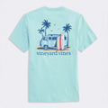Light blue t-shirt with a graphic of a van, surfboards, and palm trees on the back, featuring the 'Vineyard Vines' brand.