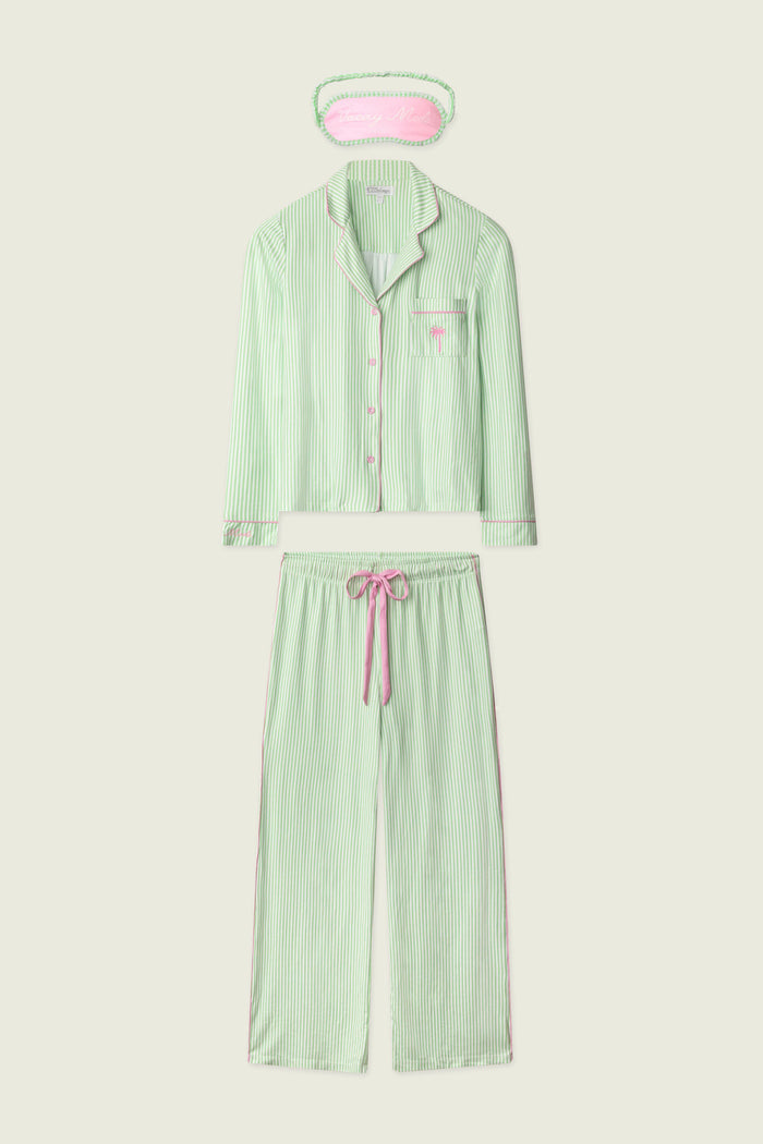 The P.J. Salvage Pupcation Palms Kiwi Stripe 3-Piece PJ Set features a light green and white striped long-sleeve button-up top, drawstring pants, and an eye mask with pink accents for a cozy, coordinated look.
