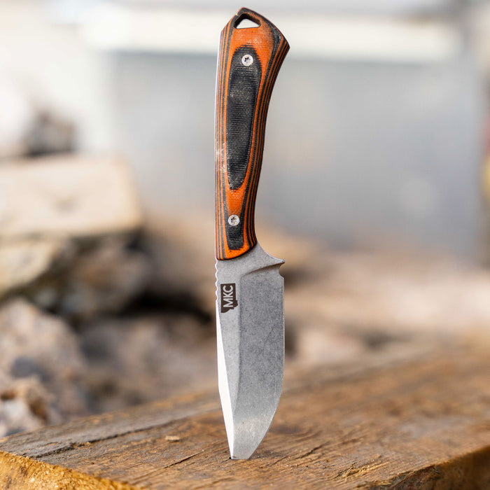 Rocker knife with an orange and black handle, featuring a durable blade, designed for outdoor and tactical use.