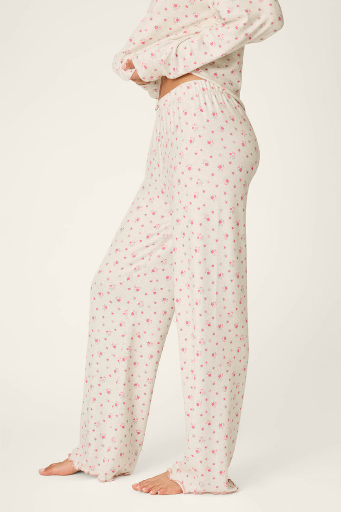 A person wearing P.J. Salvage Romantic Rose Ditsy Rose Print Pajama Pants, standing barefoot on a light background.