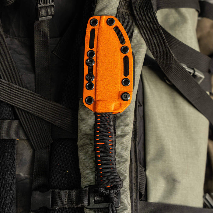Bright orange Kydex sheath for the Stoned Goat 2.0 knife attached to a tactical backpack, showcasing durability and functionality.