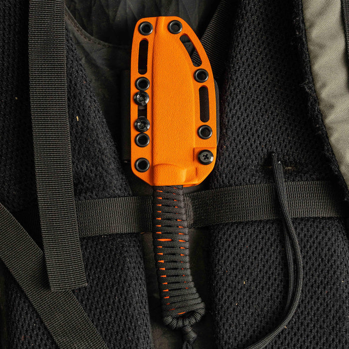 Orange Kydex sheath for the Stoned Goat 2.0 knife, secured to a textured black backpack.