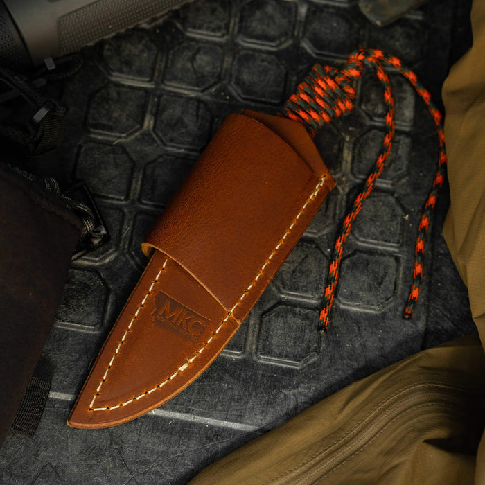 Stoned Goat 2.0 leather sheath for horizontal belt carry, featuring durable brown leather and a braided cord.
