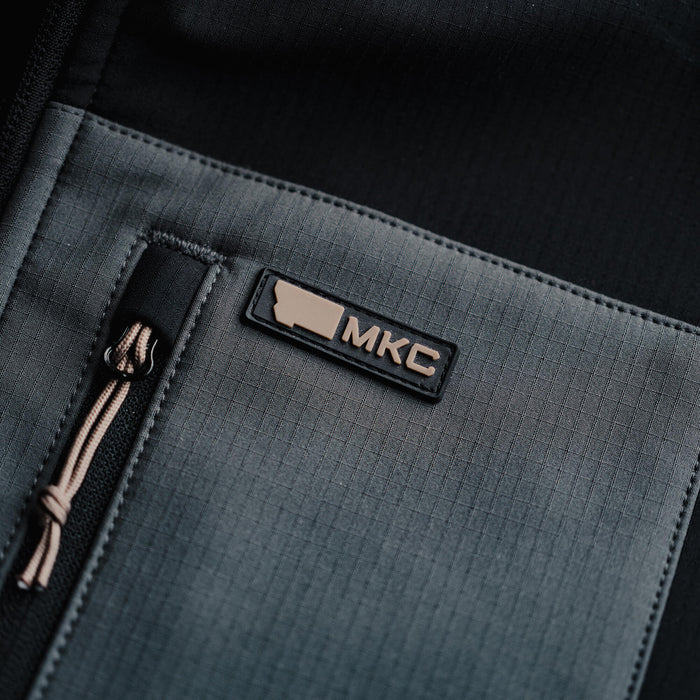 Close-up of the Tactical Striker Softshell Jacket featuring the MKC logo, showcasing its durable fabric and design.